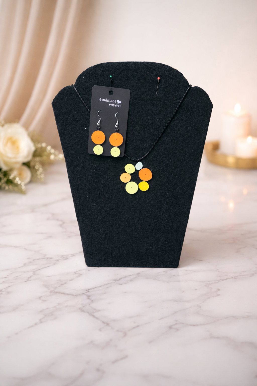 Circular-style earrings and necklace set showcasing warm, elegant orange and yellow tones.